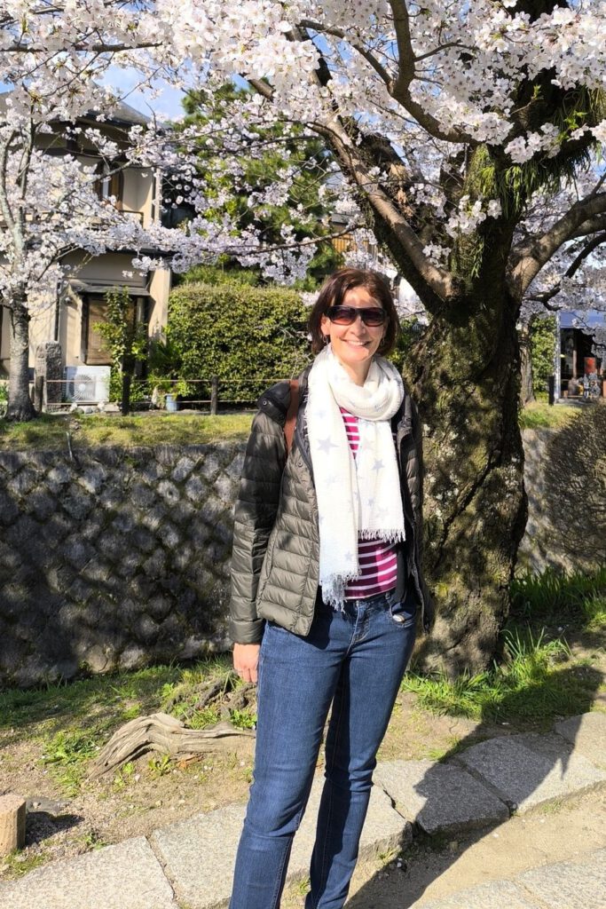 Kirsten Wunderle under a cherry tree in blossom in Japan