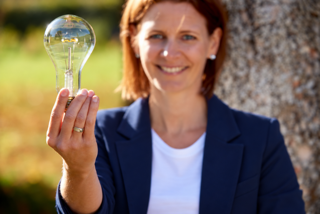 Kirsten Wunderle hält eine Glühbirne in die Kamera